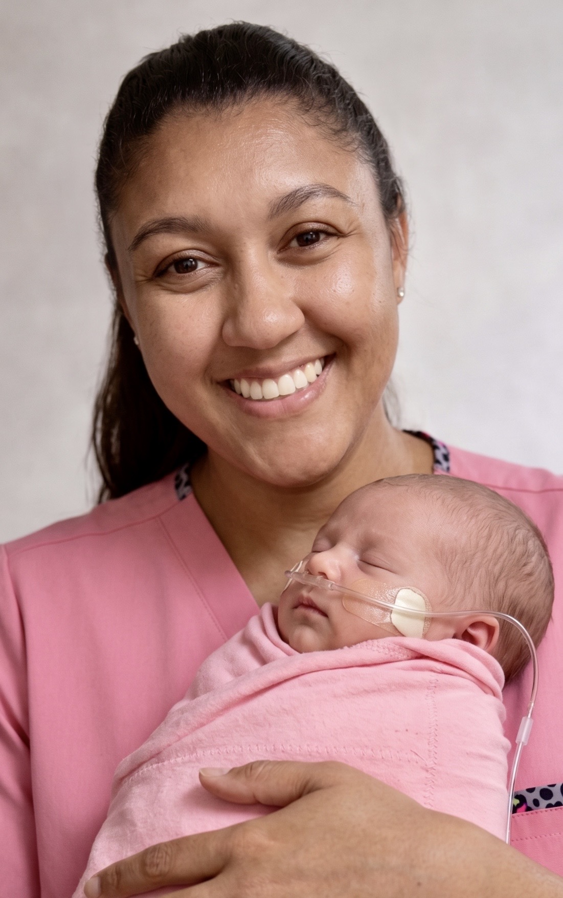 Adriele Fernandes, founder of AF Care Services, holding a newborn