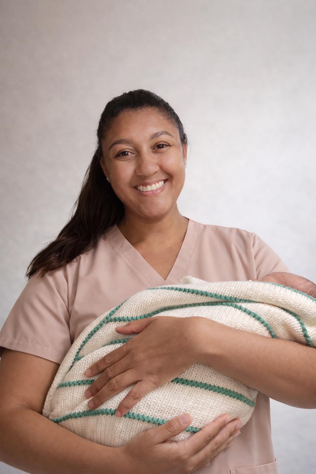 Founder of AF Care Services holding a newborn